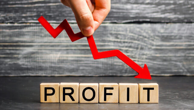 A businessman holds a red arrow to down and the inscription 