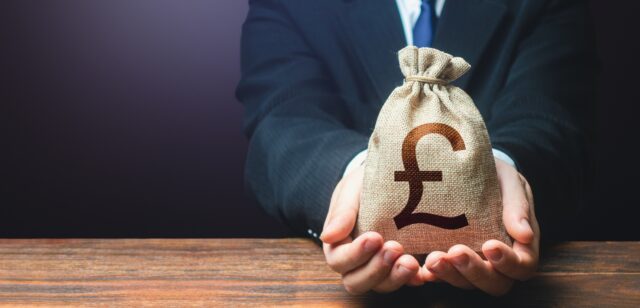 Businessman holds out british pound sterling money bag. Getting a grant, profit, attracting investments. Deposit savings. Banking and crediting. Easy Money, representing calculating investment and providing bad financial advice.