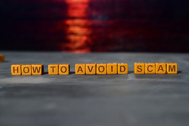 How to avoid scam? on wooden blocks. Cross processed image with bokeh background.
