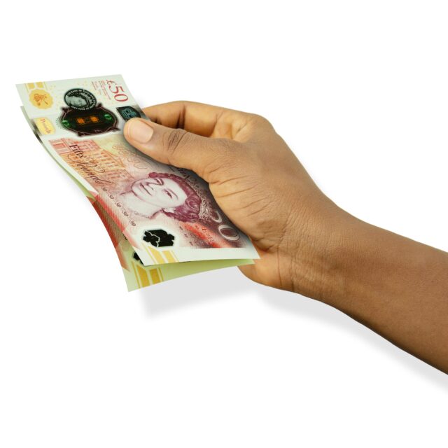 Fair hand holding 3D rendered 50 British pounds sterling notes isolated on white background, representing calculating investment and providing bad financial advice.