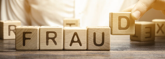 Wooden blocks with the word Fraud and man. Cheating white-collar . The crime. Theft of another's property