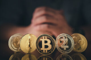 A man hand hold crypto coin symbol on reflection floor dark color tone representing fake exchange crypto scams.