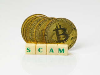 Conceptual cryptocurrency bitcoin with the word Scam on white background representing crypto scams.