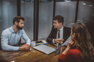 Clients consulting with solicitor over documents in office setting