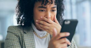 A woman, reading phone and shocked for social media post, surprise and stress on mobile for impersonation scam.
