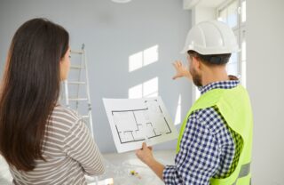 Concerned client reviewing architectural plans and blueprints