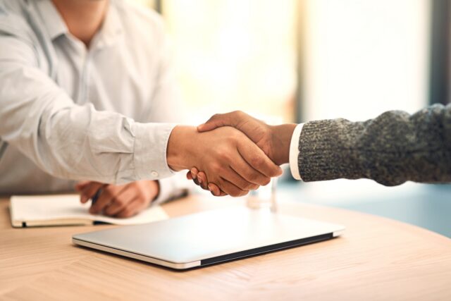 Client shaking hands with financial advisor after successful claim support