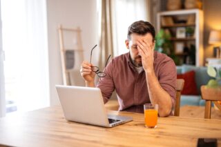 Stressed business owner reviewing financial documents and tax papers