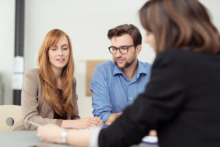 Insurance broker showing documents to a couple