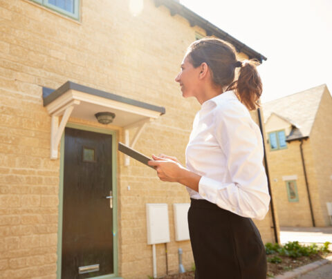 Female real estate agent looking at a house exterior