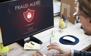 Fraud alert and padlock on computer screen symbolising protection from bank scams.