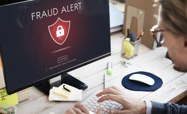 Fraud alert and padlock on computer screen symbolising protection from bank scams.