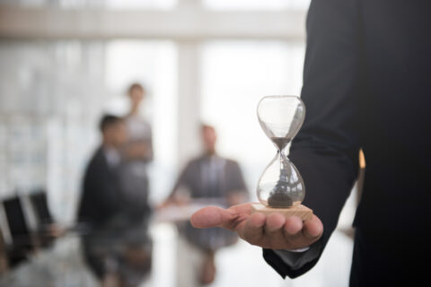 Business Man Hour Glass Time representing Time Limits