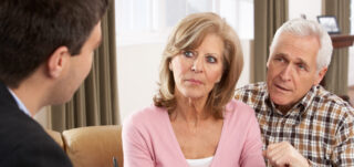 Client couple eviewing pension documents with adviser to discuss mis-sold claim.