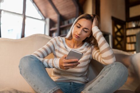 Person realising suspicious crypto investment messages on their phone.