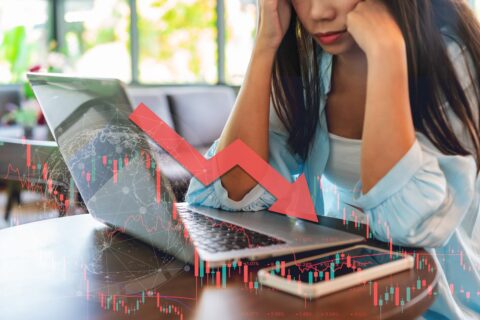 A middle-aged couple in the UK sitting at a kitchen table, looking worried as they review financial paperwork and investment statements. The scene conveys the stress and uncertainty caused by being mis-sold Concept Capital Group investments.