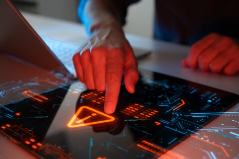Man interacting with a holographic touchscreen interface in red colour symbolising FCA warning about Liberty Bank and Liberty Coin Exchange scam operations in the UK.