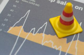 Traffic cone on volatile financial graph symbolising UCIS mis-sold investments.