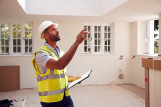 Chartered surveyor inspecting a residential property for defects in the UK