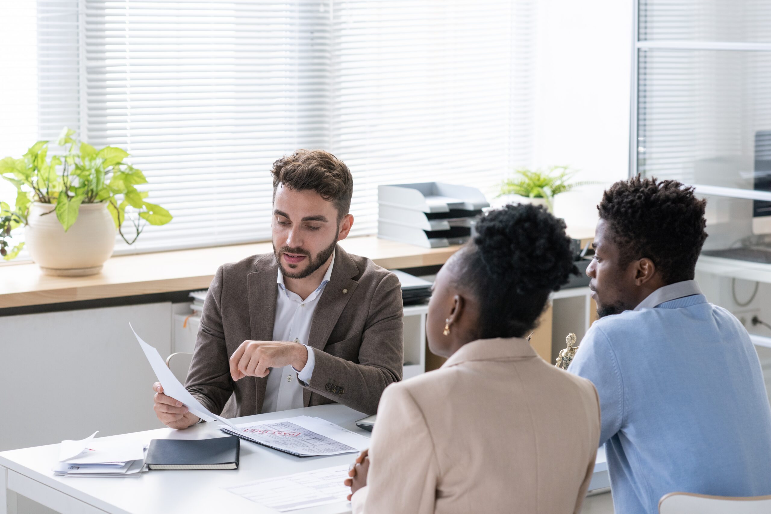 Solicitor reviewing investment documents with concerned clients during a financial mis-selling consultation.
