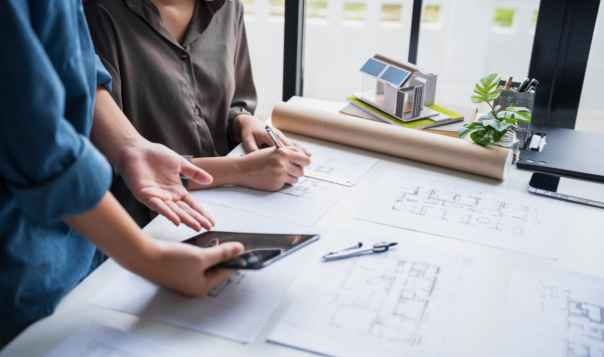 Architect and construction professionals reviewing project drawings to assess responsibility for building defects.