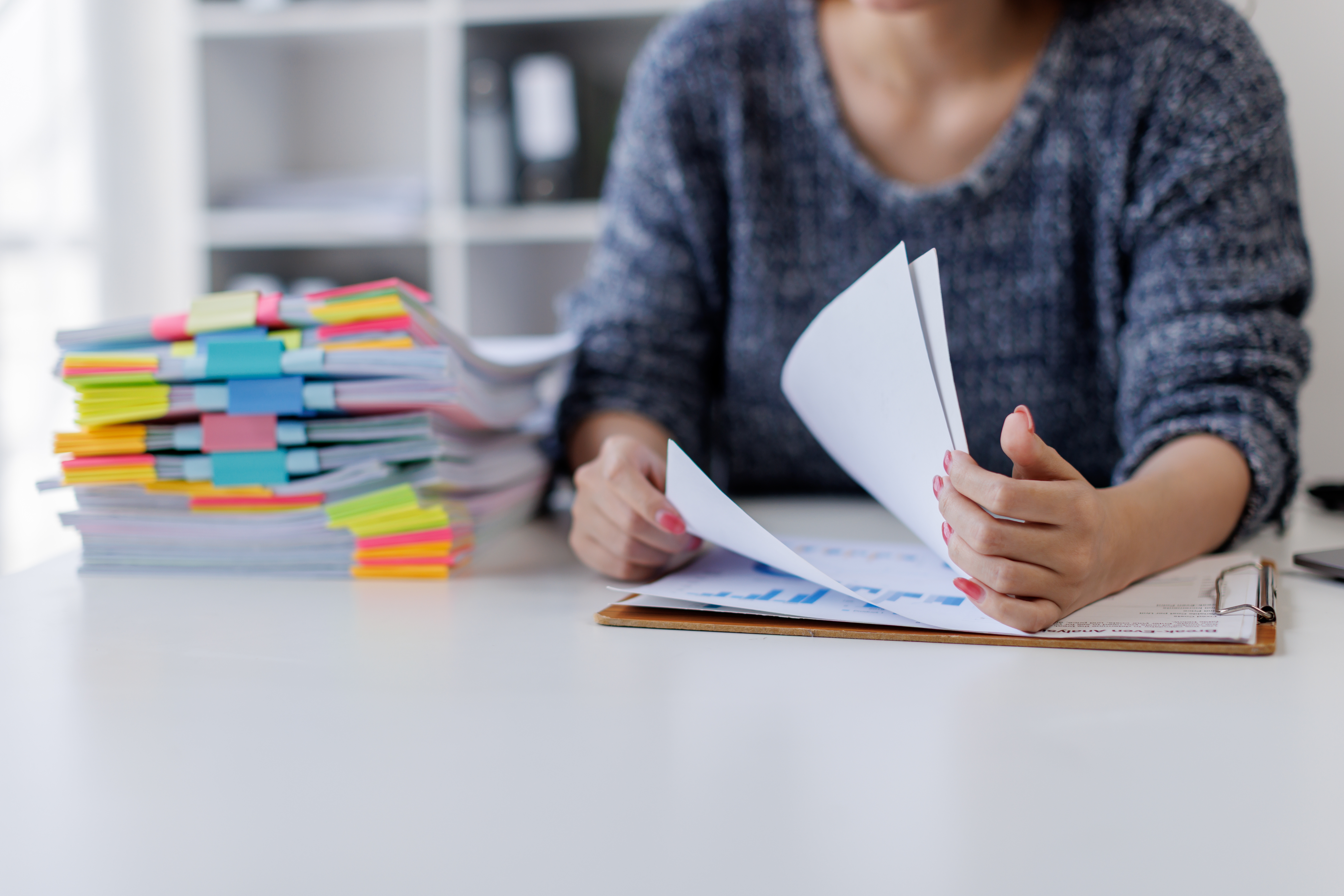Person reviewing and organising paperwork at a desk